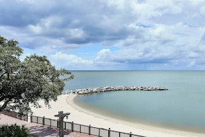 A beach with a wooden walkway and a rocky breakwater.