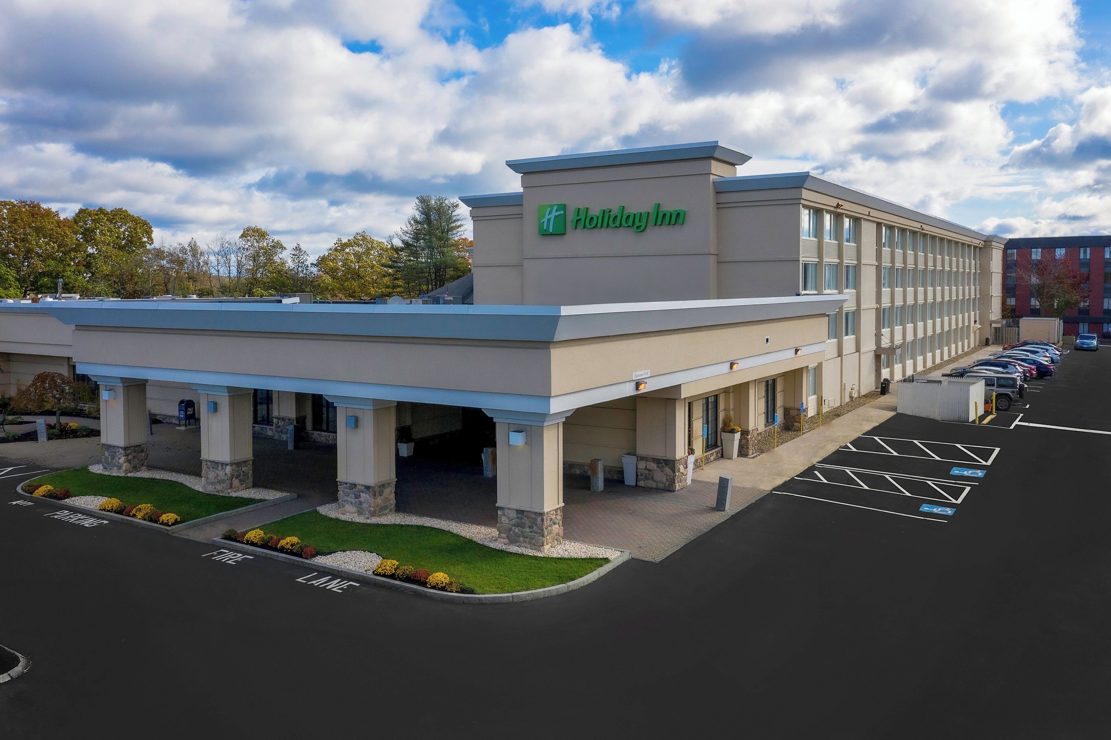 A Holiday Inn hotel with a parking lot and covered parking area.