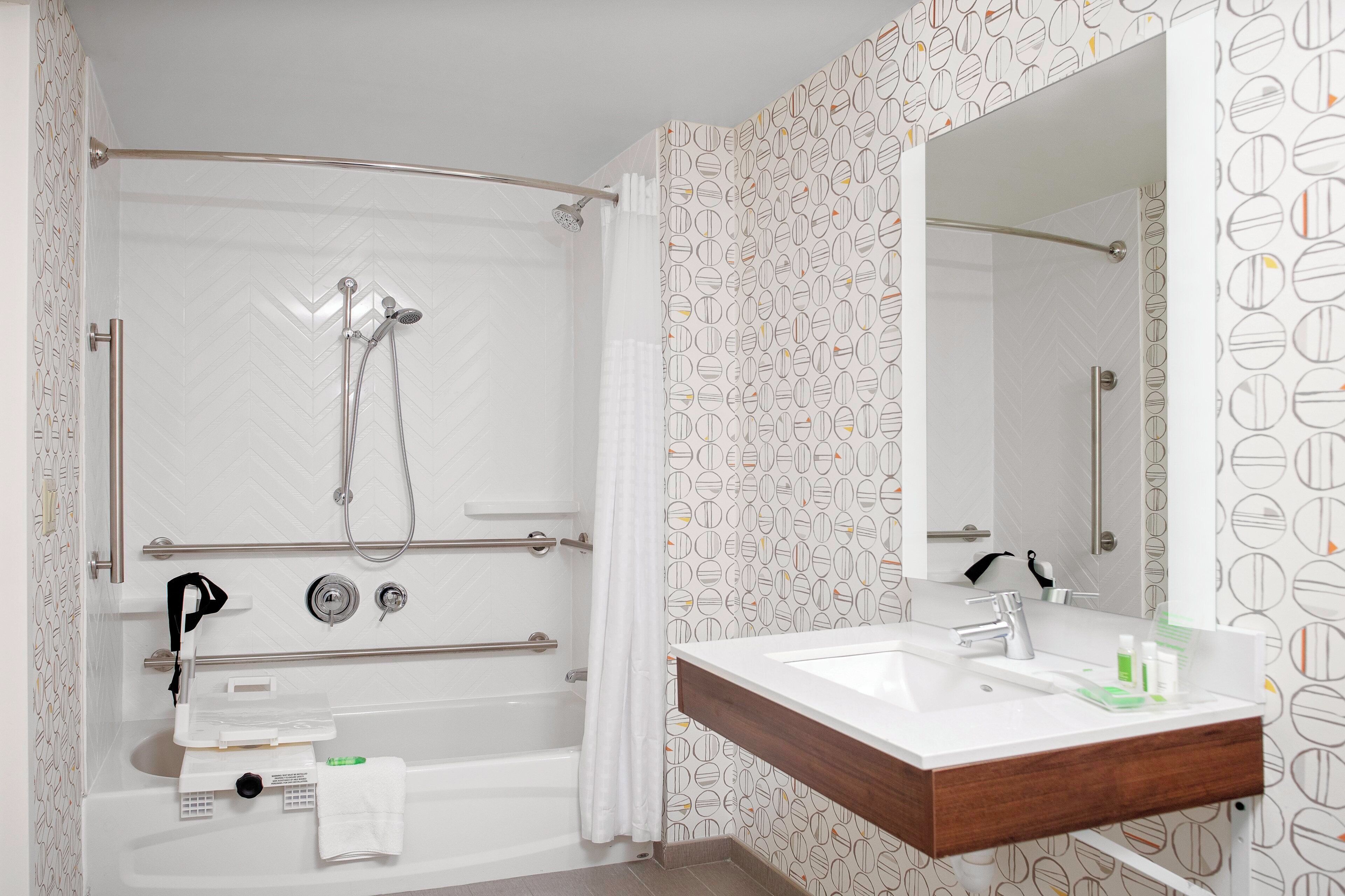 Ein Badezimmer mit Dusche, Badewanne, Waschbecken und Spiegel.