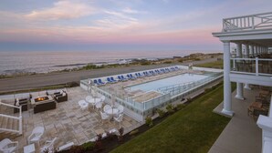 A rooftop pool area with lounge chairs and a view of the ocean. - Ocean House Hotel at Bass Rocks (Gloucester)