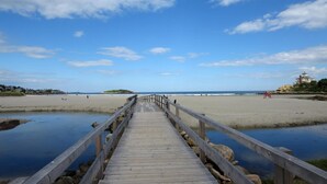 A wooden boardwalk leading to a beach with a clear sky. - Ocean House Hotel at Bass Rocks (Gloucester)