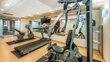A gym with treadmills, elliptical machines, and weight machines.