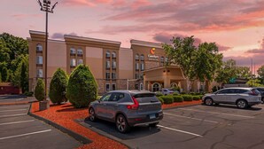A hotel with a parking lot, a sign for Comfort Inn & Suites, and a clear sky. - Comfort Inn & Suites East Hartford - Hartford (East Hartford)