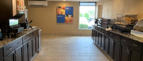 A modern kitchen with a coffee machine, a microwave, and a buffet setup.