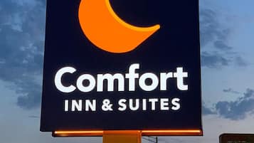 A sign for Comfort Inn & Suites with a crescent moon logo.