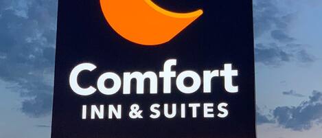 A sign for Comfort Inn & Suites with a crescent moon logo.