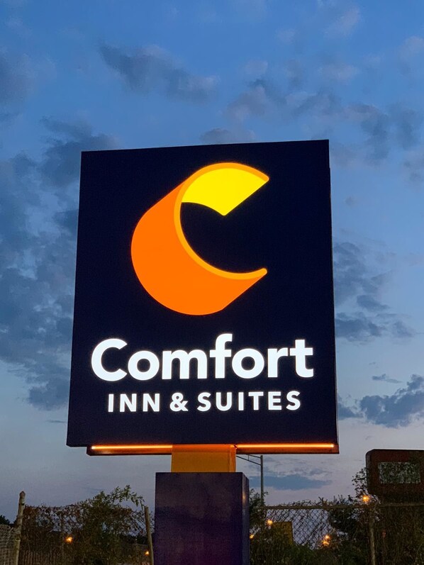 A sign for Comfort Inn & Suites with a crescent moon logo.
