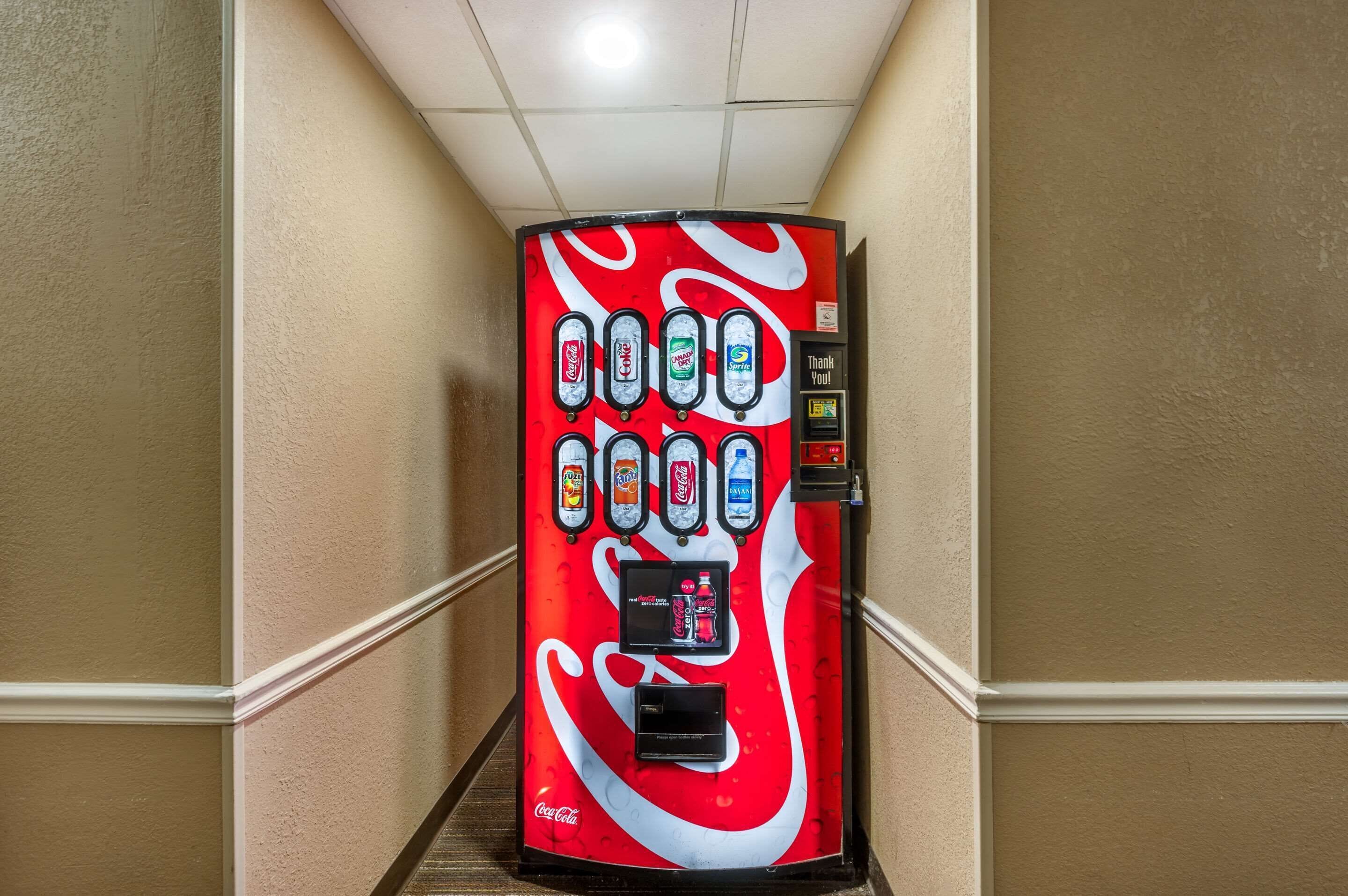 En Coca-Cola automt med beige vægge og flisegulv i en gang.