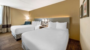 A hotel room with two beds, a nightstand with a lamp, and a wall-mounted light fixture. - Comfort Inn & Suites East Hartford - Hartford (East Hartford)