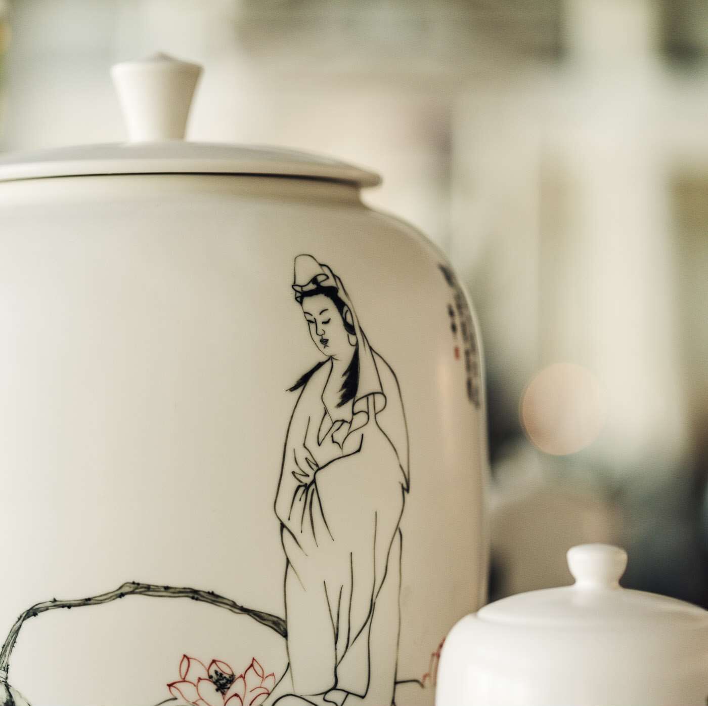 A ceramic pot with a traditional figure and floral design.