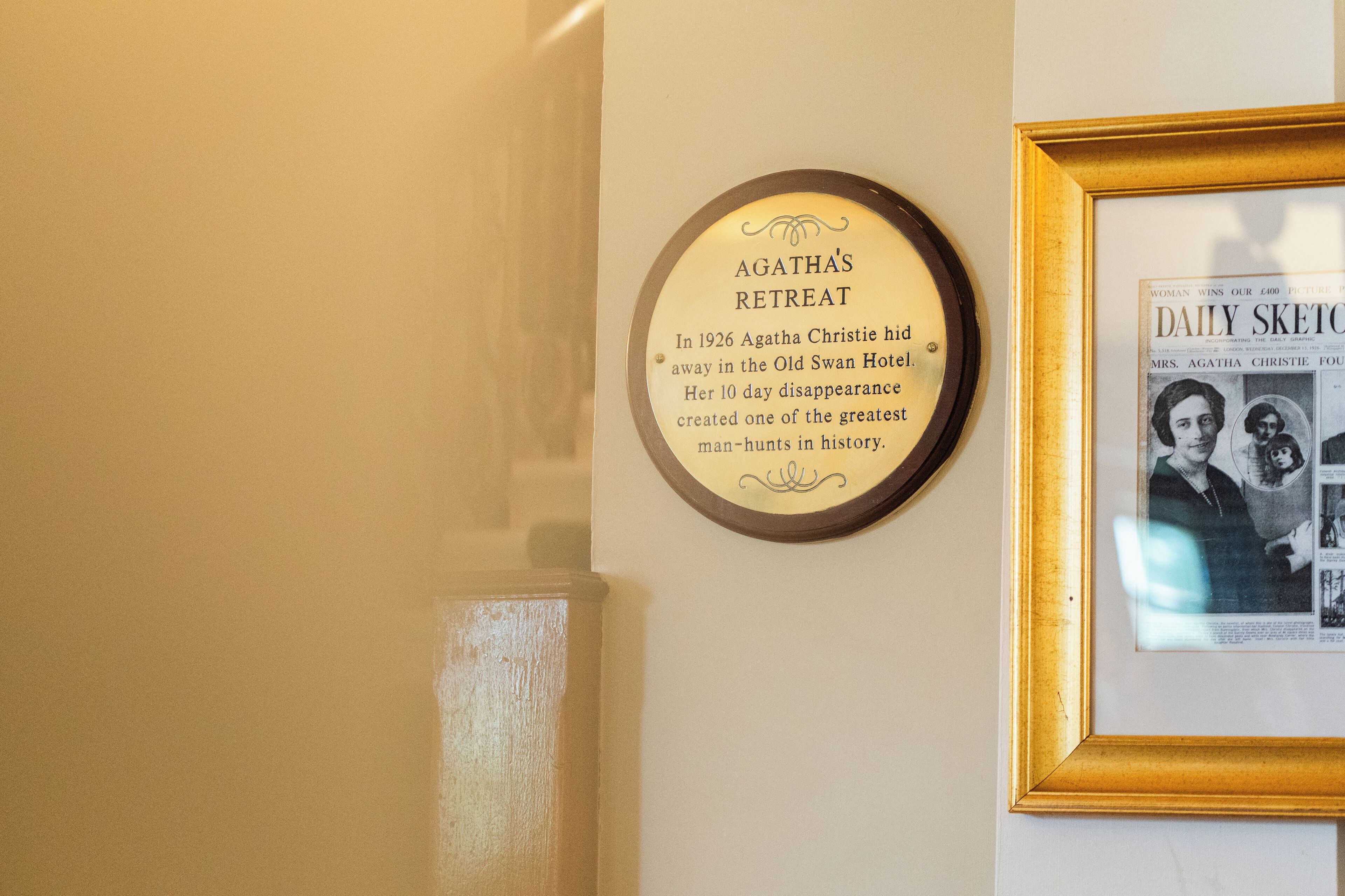 A wall with a framed newspaper clipping and a plaque about Agatha Christie's 1926 disappearance.