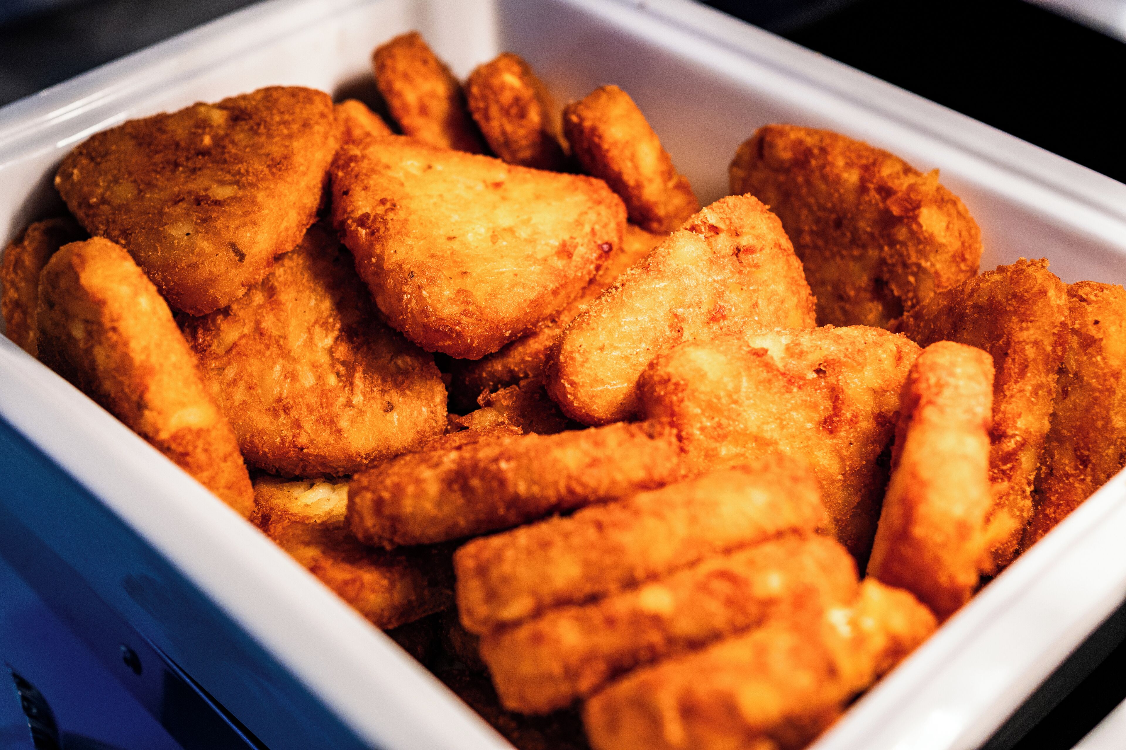 A white container filled with golden-brown fried food items.