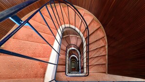 A spiral staircase with a wooden finish and a metal railing. - Hotel Ambassador Tre Rose (Venice)