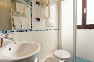 Un bagno con lavandino bianco, un water e zona doccia.