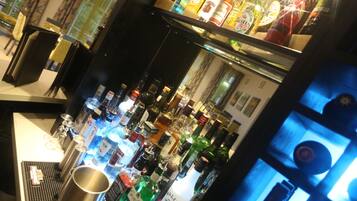 Una zona de bar con varias botellas y una máquina de café.