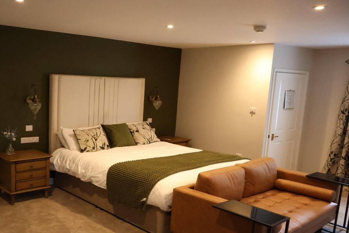 A bedroom with a bed, a nightstand, a chair, and a dresser.