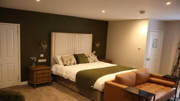 A bedroom with a bed, a nightstand, a chair, and a dresser.