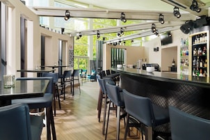 Eine moderne Bar mit einer langen Theke, Barhocker und einer gut sortierten Spirituosenregal.