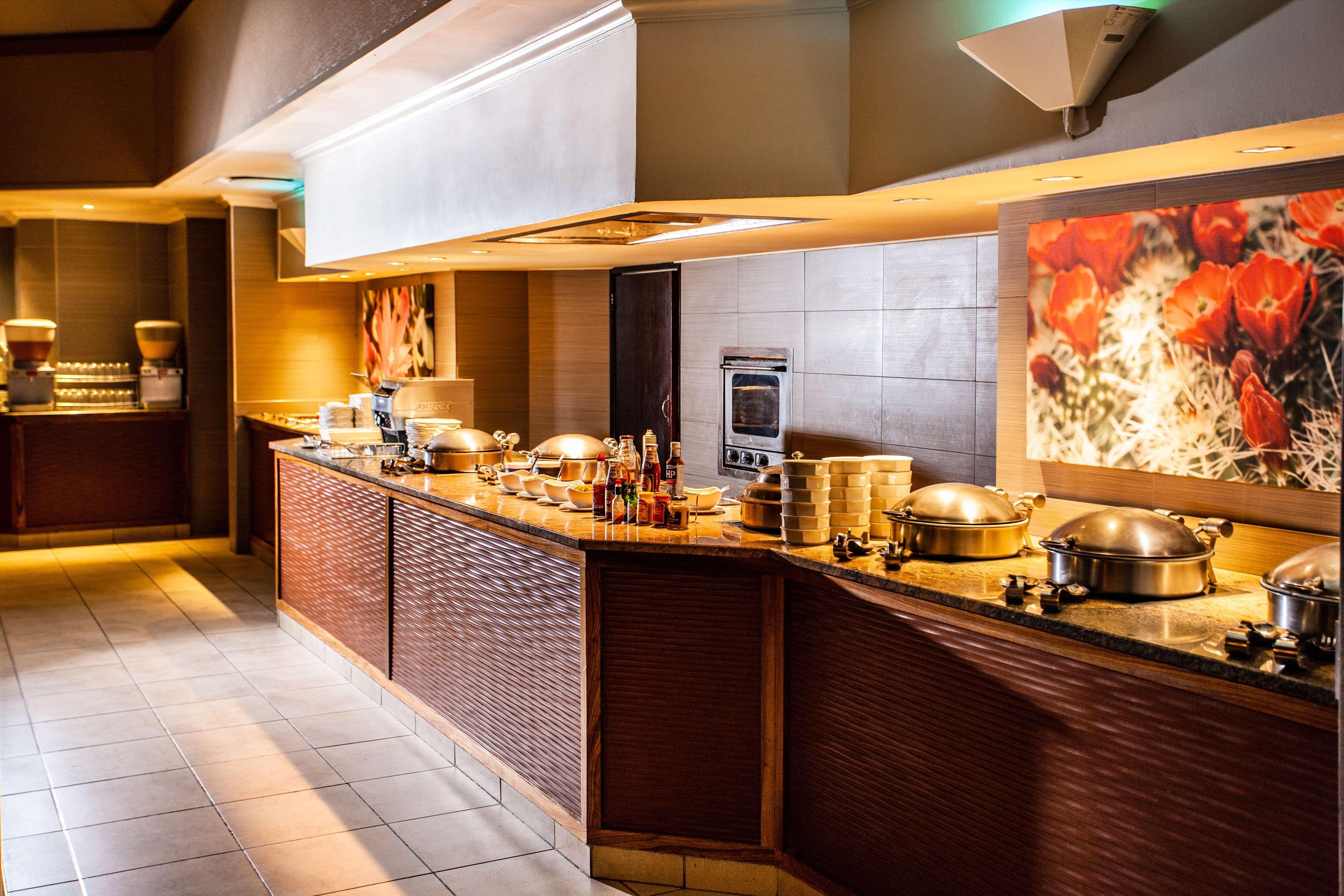 A modern kitchen with a large island, built-in appliances, and a decorative wall piece.