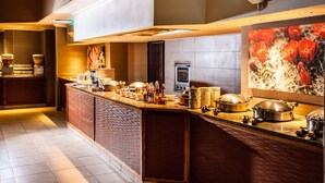 Una cocina moderna con una isla grande, electrodomésticos integrados y un elemento decorativo en la pared.
