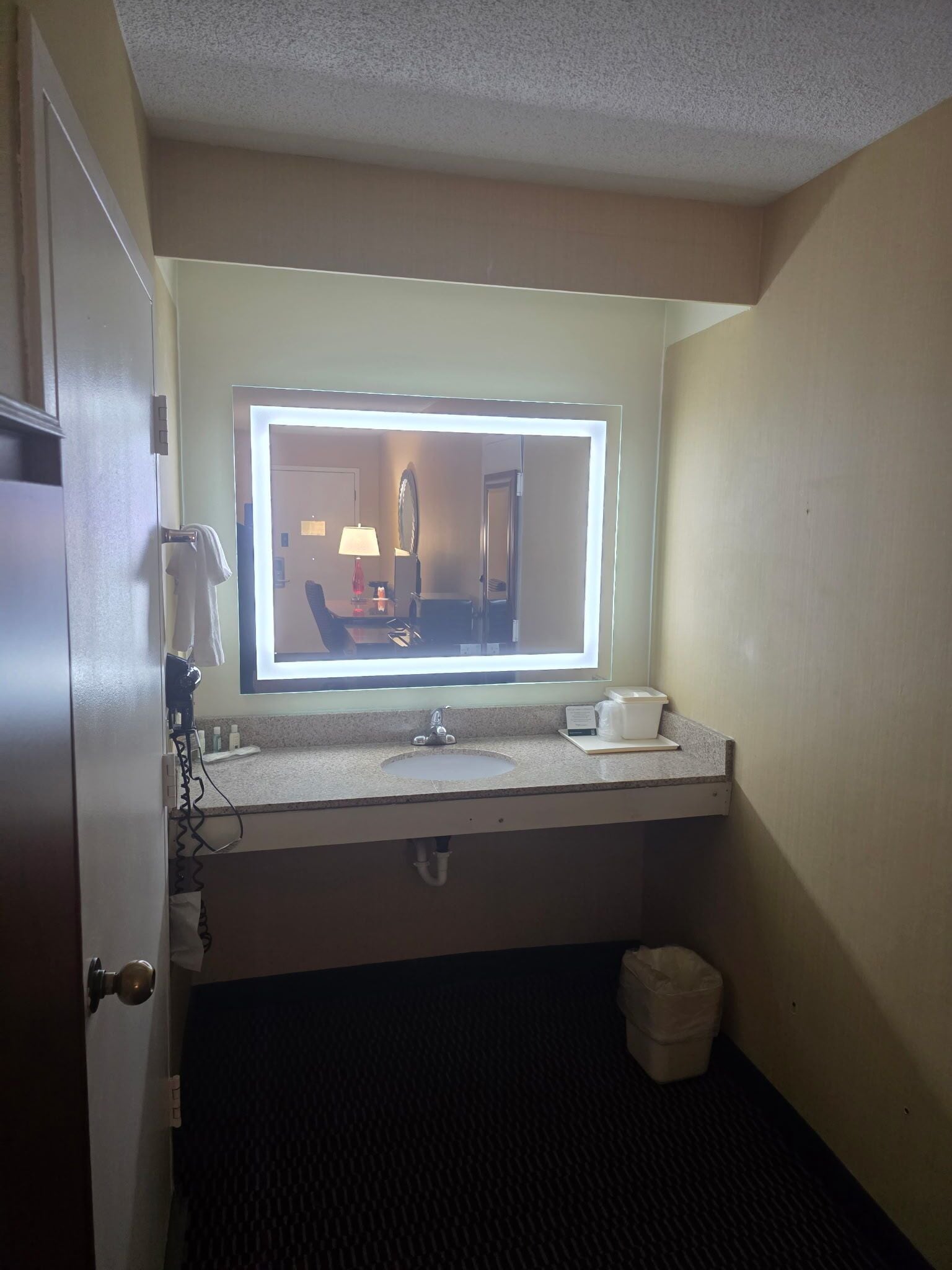 Un bagno d'albergo con un lavabo, uno specchio e un portasciugamani.