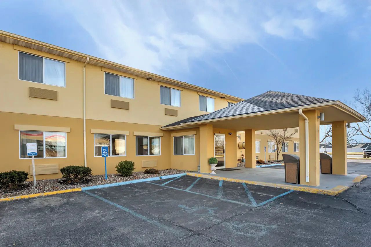 A multi-story hotel with a covered entrance and a parking lot.