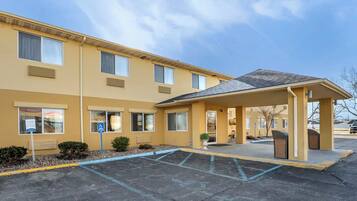 A multi-story hotel with a covered entrance and a parking lot.