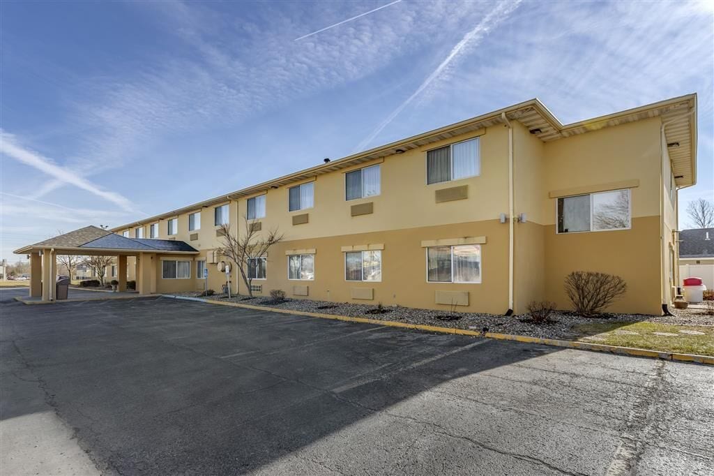 A multi-story motel with a flat roof, large windows, and a covered parking area.