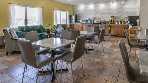 A modern kitchen with a central island, a dining area with a large table and chairs, and a living area with a sofa and a coffee table. - Quality Inn Kirksville (Kirksville)