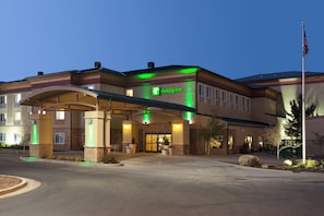Un hotel Holiday Inn con ingresso coperto, posti a sedere all'aperto e un'asta con bandiera.