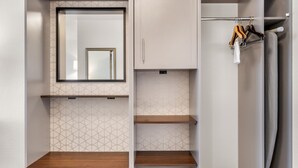 Ein modernes Badezimmer mit Spiegel, Schrank und Handtuchhalter.