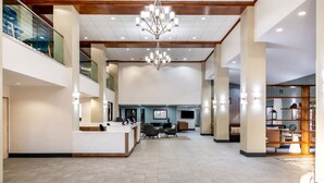 Eine großzügige Lobby mit Empfangsschalter, Sitzbereich und einer Chandelier.