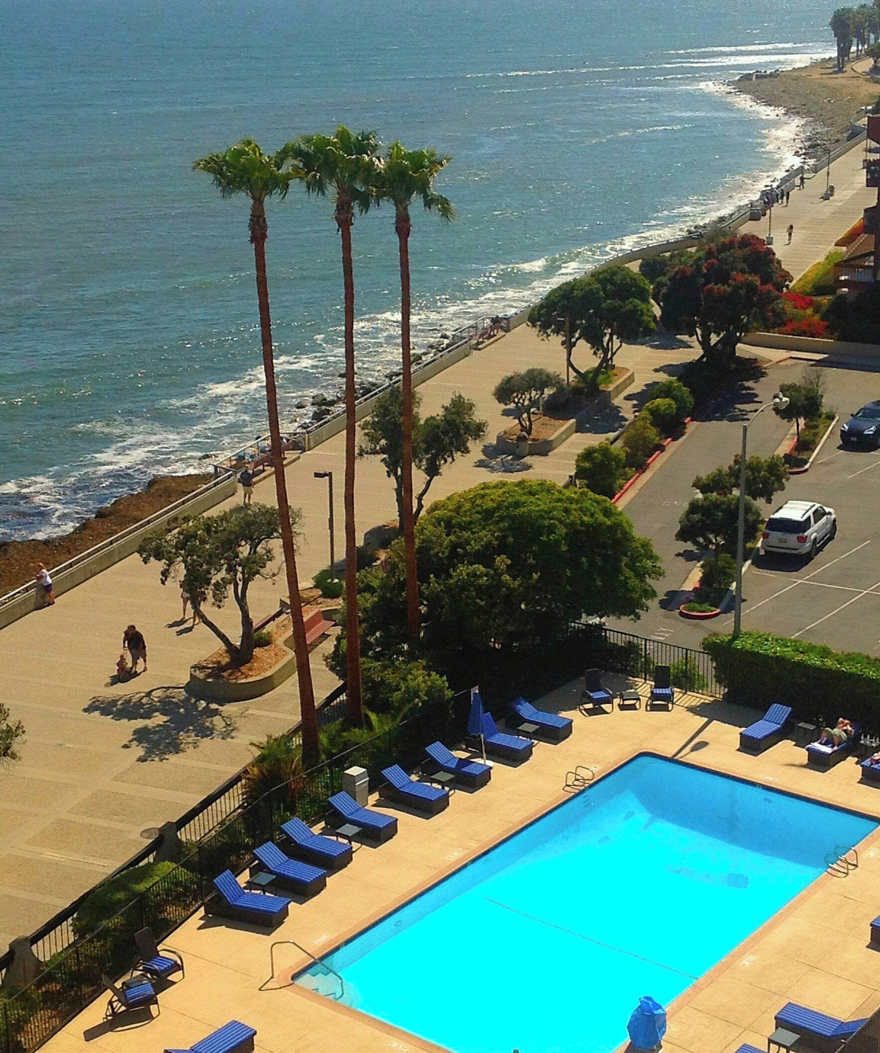 Una piscina al aire libre, sombrillas, sillones reclinables de piscina