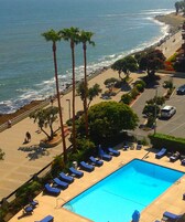 Una piscina al aire libre, sombrillas, sillones reclinables de piscina