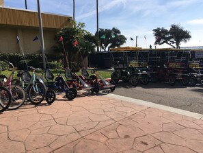 Un espacio pavimentado con bicicletas y karts estacionados.