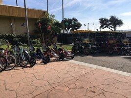 Un espacio pavimentado con bicicletas y karts estacionados.