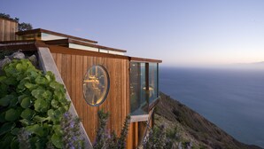 Un edificio moderno de madera con amplios ventanales de vidrio que dan a un paisaje costero.
