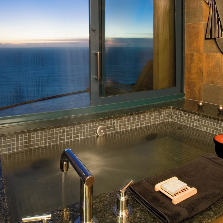 A bathroom with a bathtub, a towel, and a soap dish.