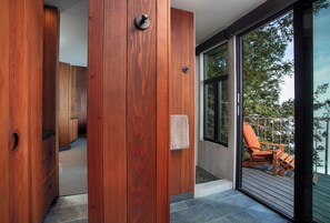 A wooden interior with a sliding glass door leading to an outdoor deck.