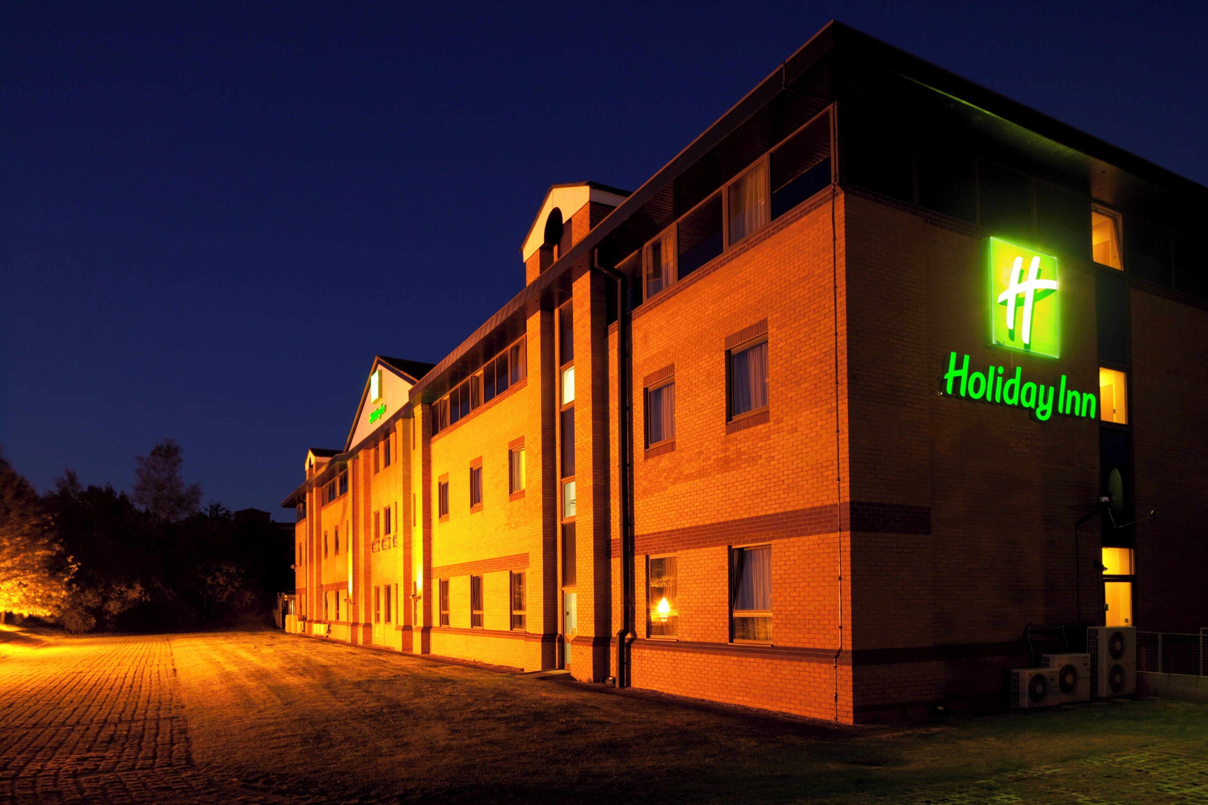 Un hotel Holiday Inn amb façana de maó i nombroses finestres.