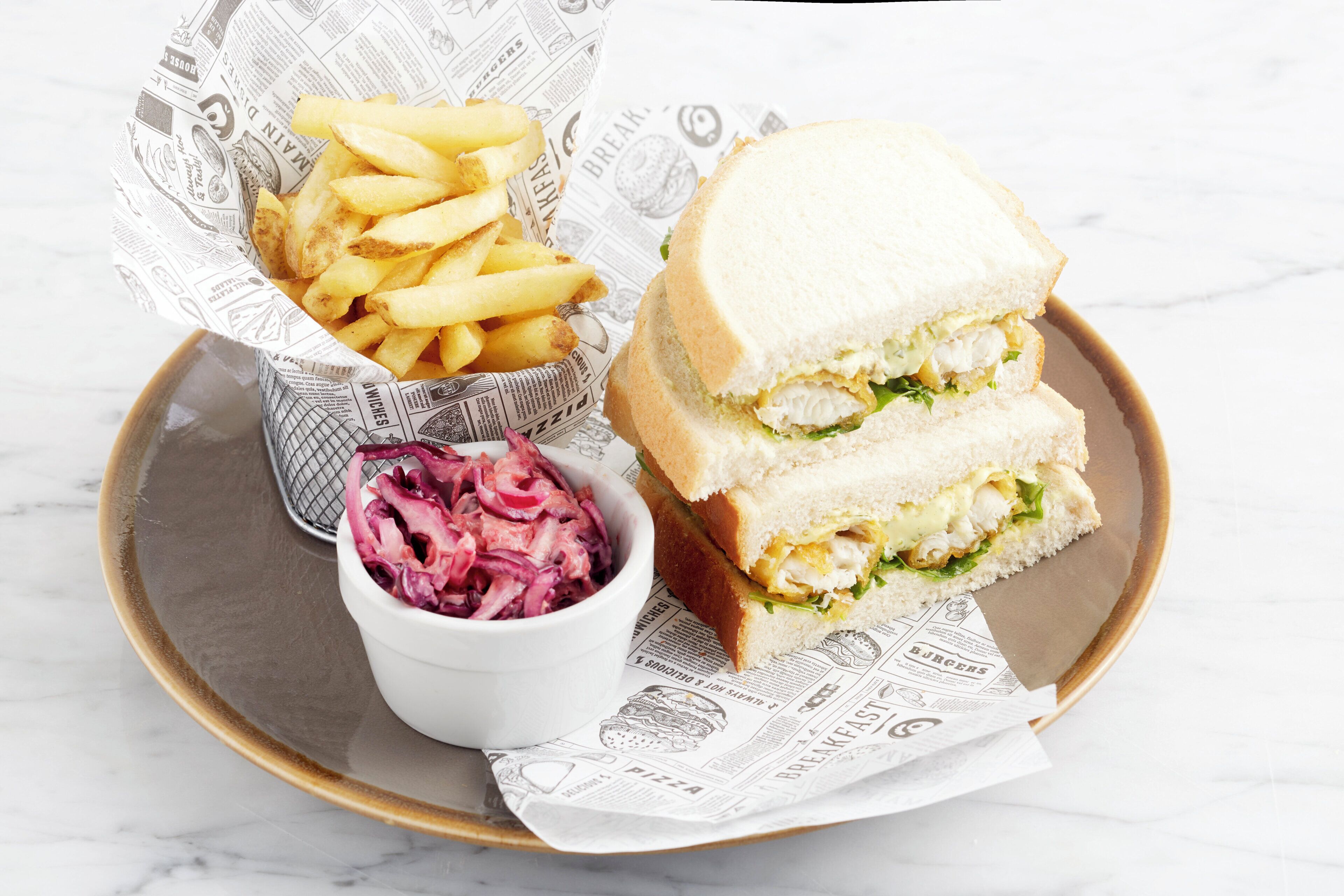 Ein Tablett mit einem Sandwich, Pommes und Krautsalat.