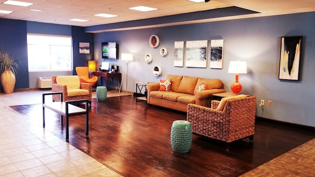 A spacious lobby with a large sofa, two armchairs, a coffee table, and a TV mounted on the wall. - Beach Boutique Hotel (Rehoboth Beach)