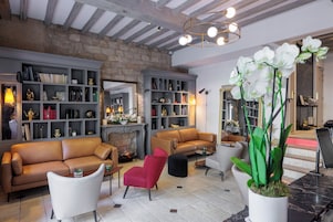 Un amplio salón con chimenea, sofás de cuero y una gran estantería.