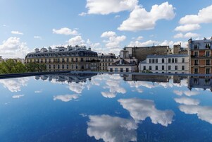Un pueblo europeo histórico con arquitectura clásica reflejada en aguas tranquilas.