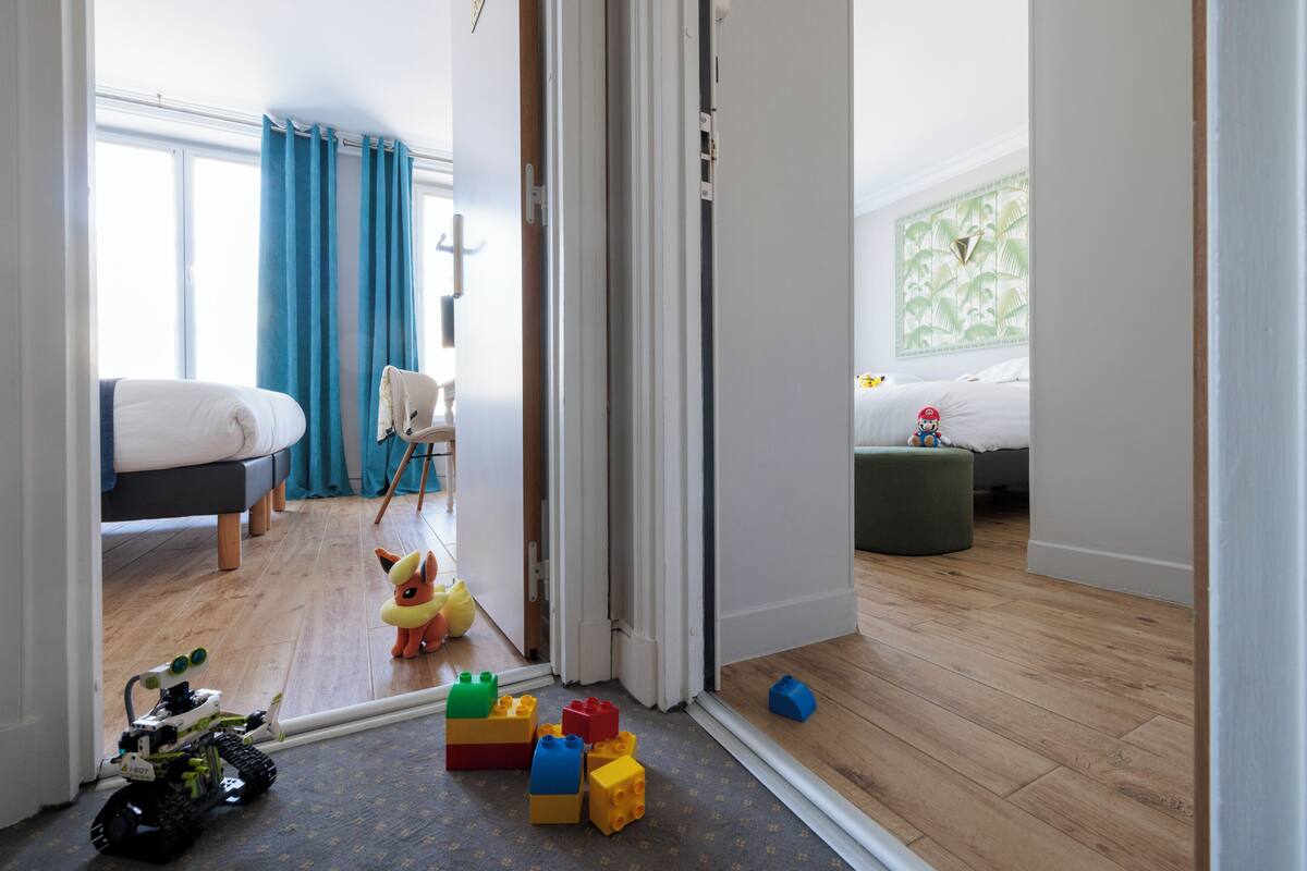 A child's playroom with a bed, toys, and a robot toy on the floor.
