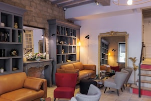 A cozy living room with leather sofas, a fireplace, and a bookshelf.
