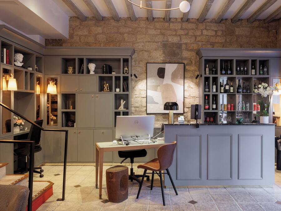 A modern kitchen with a built-in island, a dining area, and a workspace with a computer.