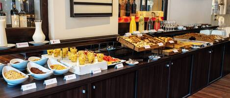 A buffet with various food items and beverages, including a sign for 'Fernetbranca MINTTONIC'.