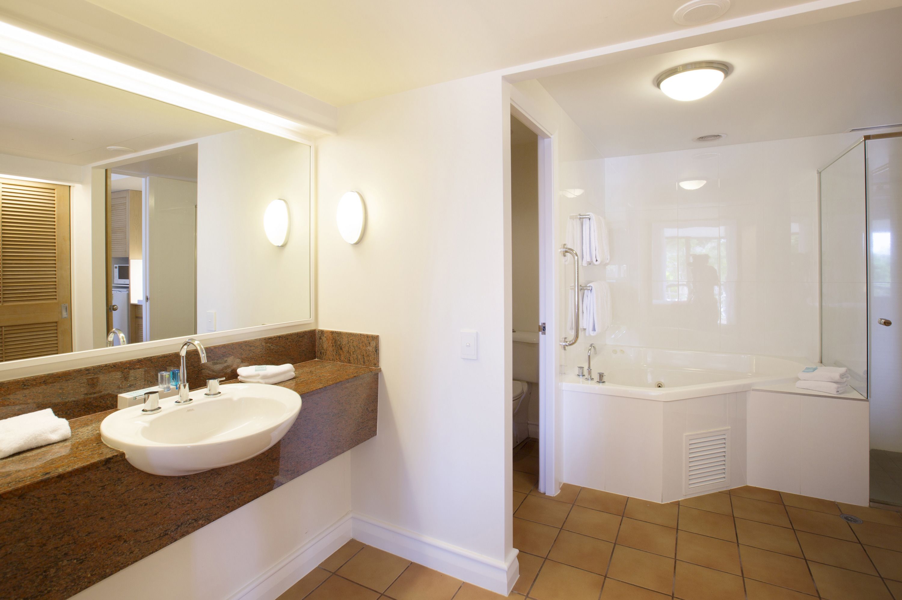 A modern bathroom with a large sink, a bathtub, and a shower area.