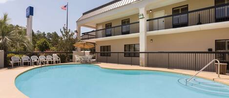 Ein Hotel mit Schwimmbad, Außenbereich und einer Fahnenstange mit der amerikanischen Flagge.